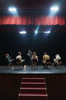 A group of actors rehearsing on stage under spotlights, creating an immersive theater experience.