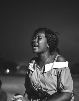 A powerful monochrome image of a woman passionately shouting, evoking strong emotions.