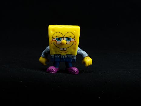 Close-up of a colorful Spongebob toy figure against a black background.