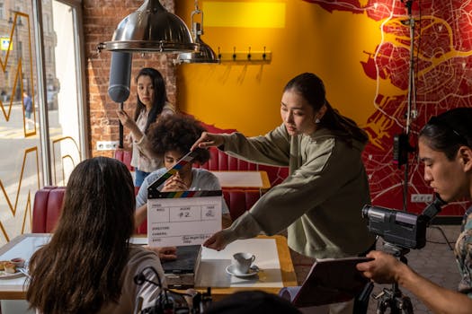 Diverse film crew with clapperboard in café setting filming scene.