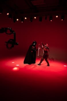 Dramatic studio fight scene with actors in costumes under red lighting.