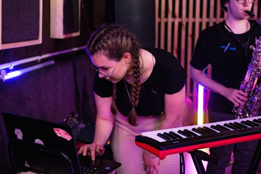 Musicians working in a vibrant studio with keyboards and saxophone. Creative energy and focus.