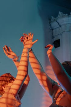 Two people with raised hands under atmospheric lighting, showcasing modern art style.